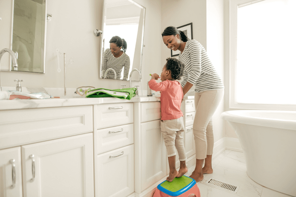 mother with daughter teaching good oral habits and teeth brushing