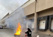 Woman praciticing fire extinguisher saftey during Code 3 Safety & Training class