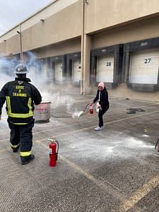 Woman using Fire Extinguisher during Code 3 Safety & Training class