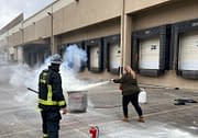 Female practicing the use of Fire Extinguisher safety during Code 3 Safety & Training Course.