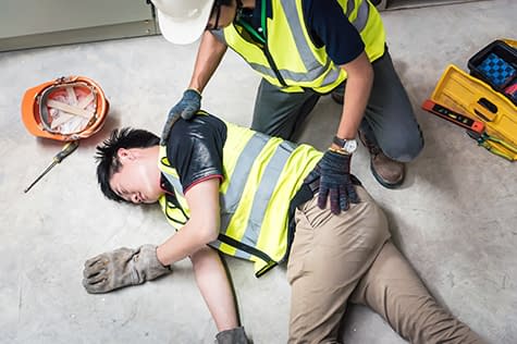 Worker helping injured coworker at construction site