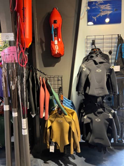 wetsuits and spearfishing accessories in a dive shop