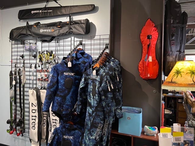 wetsuits on display inside a dive shop