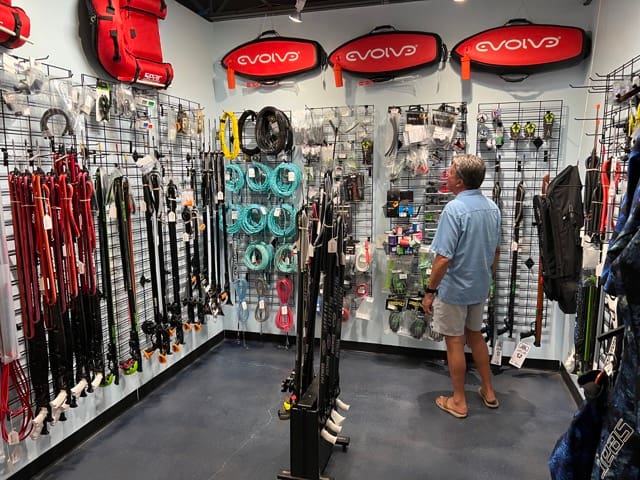 a man shopping among lots of spearfishing gear inside a dive shop