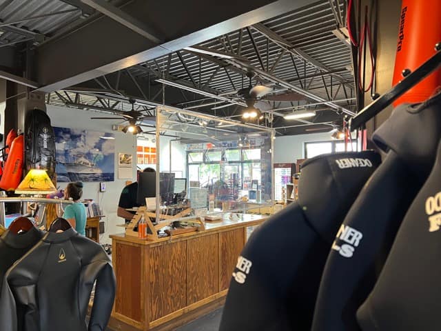 inside of dive shop over shoulder of wetsuit from desk counter