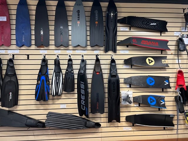 fins hanging on a wall displayed inside a dive shop