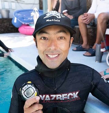 Chris Funada headshot holding a record stopwatch for static breathold