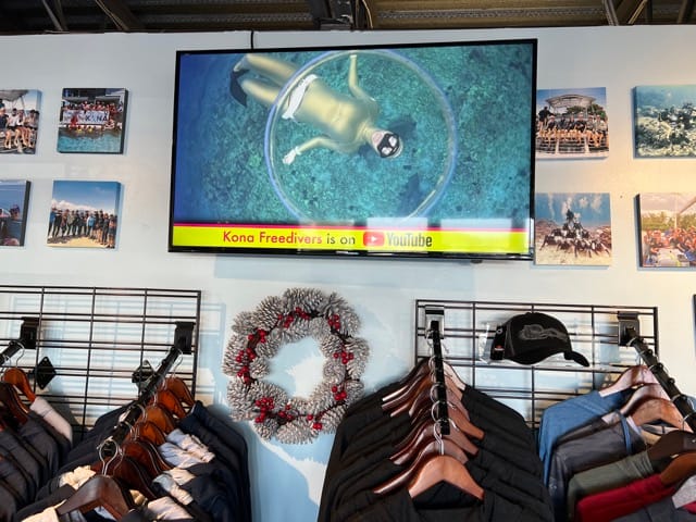 inside a dive shop tv on a wall and clothing below