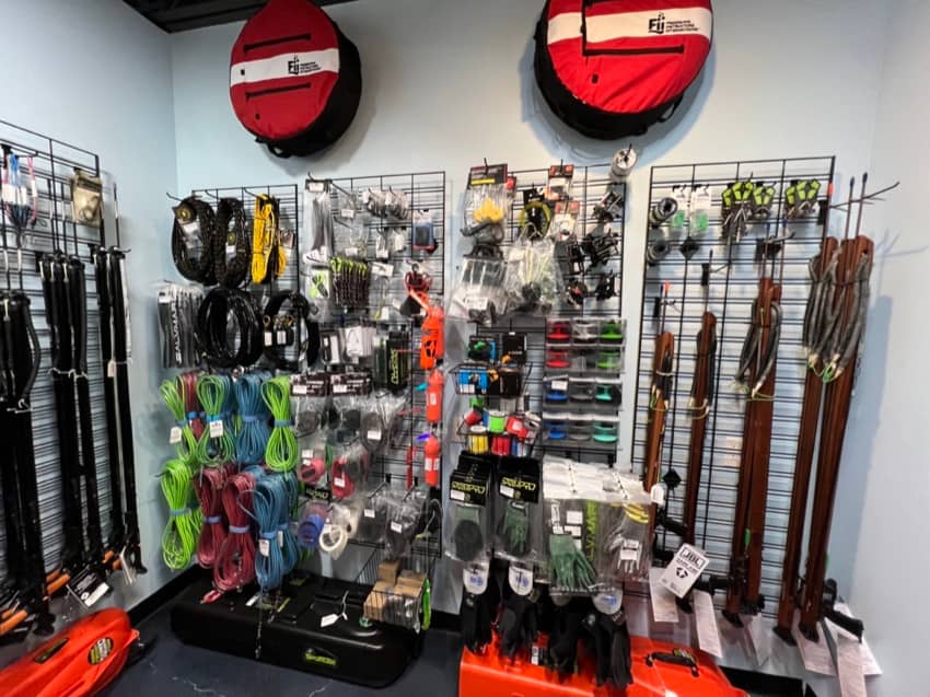 Freediving and spearfishing equipment on display on the wall