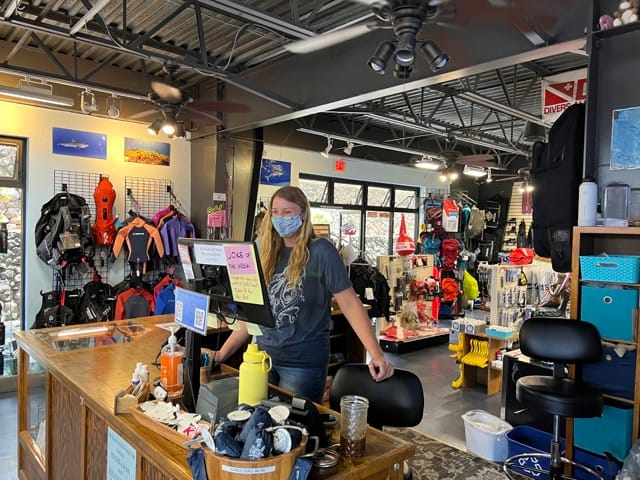 person standing at a front desk in a dive shop