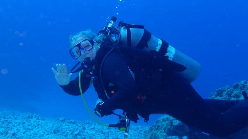 scuba diver waiving underwater while diving