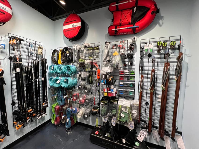 spearfishing gear hanging from dive shop wall display