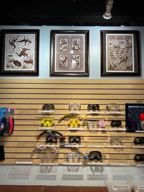 wall with scuba diving masks and pictures of Hawaiians spearfishing