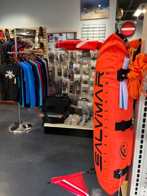 inside of dive shop inflatable float with rash guards hanging behind