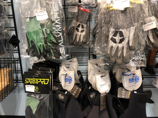 wall with spearfishing gloves on display
