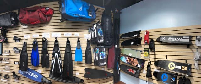 a corner in a dive shop with fins and bags