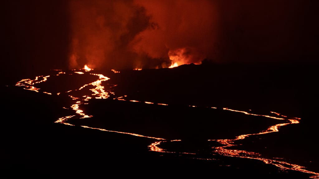 lava fountianing and running down a slope at night