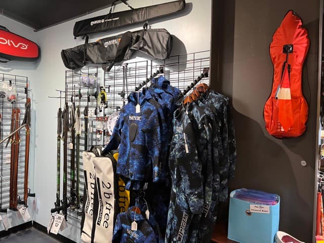 wetsuits and other spearfishing and freediving gear inside a dive shop