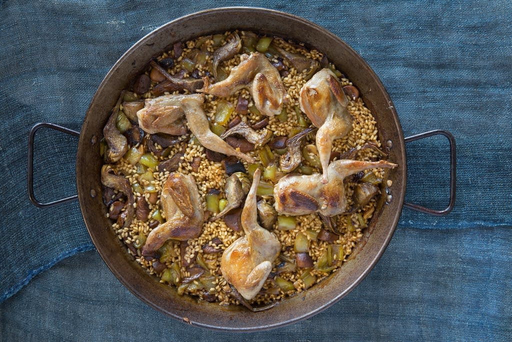 Spanish quail and porcini mushroom rice with artichokes served in large at Boqueria Spanish restaurant in NYC and DC.
