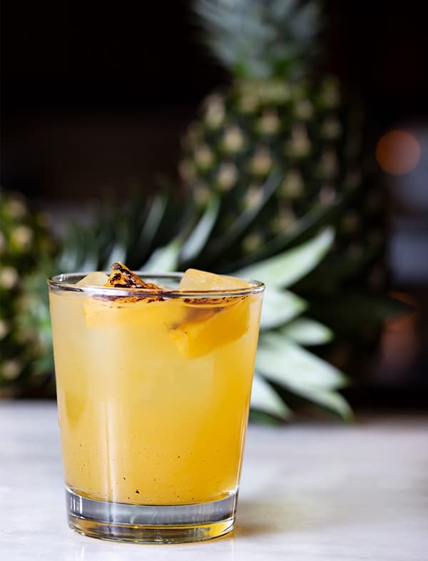 Pineapple Sangria in a glass garnished with grilled pineapple