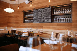 Boqueria’s Dupont Circle tapas bar set for a private event with the nights dishes on a chalkboard surrounded by sparkling water bottles.