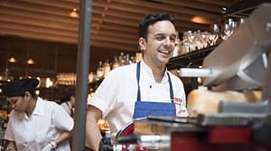 Chef Marc Vidal smiles while working in the kitchen of Boqueria Spanish restaurant and tapas bar in NYC and DC.