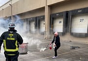 Woman using Fire Extinguisher during Code 3 Safety & Training class