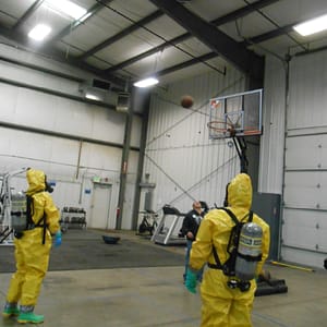 Men in Hazmat suits playing basketball