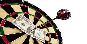 Dartboard with dart and dollar in the middle
