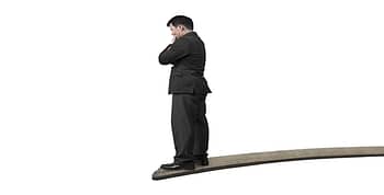 Man in a suit standing at the end of a divingboard