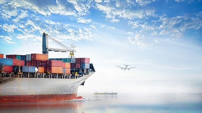 Container ship with airplane flying