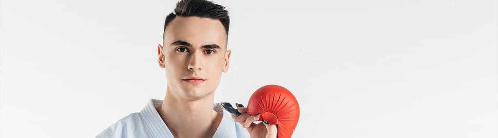 Athlete holding a fitted mouthguard and boxing glove.