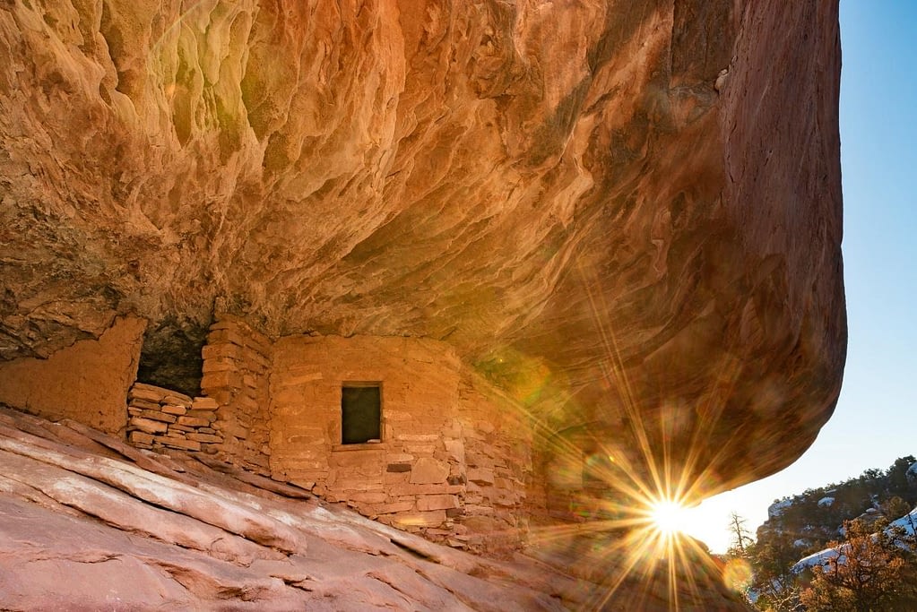 Sunburst popping through the rocky overhang of an ancient ruin