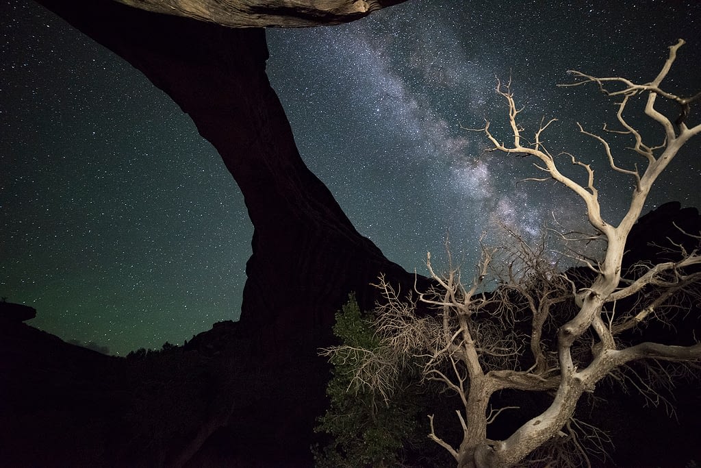 Colorful Milky Way with a silhouette arch.