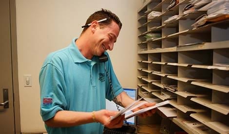 man checking mail in a mail room