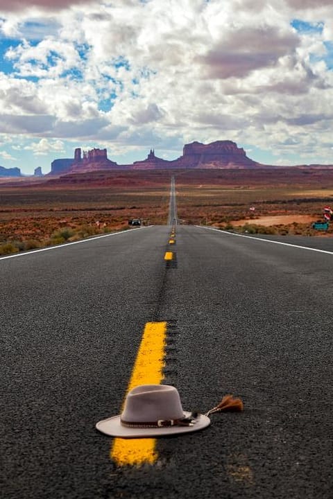 Hat on Bears Ears road trip with red rock formations in back.