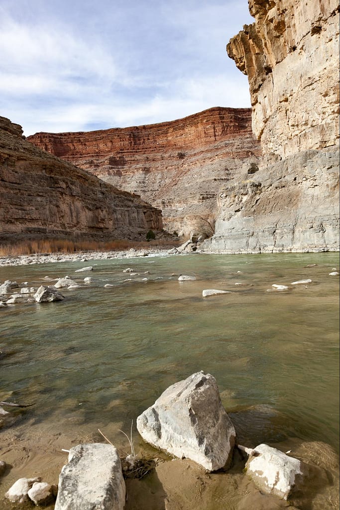Detail of the river with rocks in front to illustrate the canyon geology.