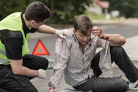 General Workplace CPR, FA, Fire Safety Category-CPR-AED-First Aid-Bloodborne Pathogens course Injured pedestrian being taken care of by safety worker